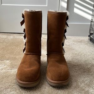 Ugg Boots w/ bows on the side and an ugg boot cleaning/maintenance kit.